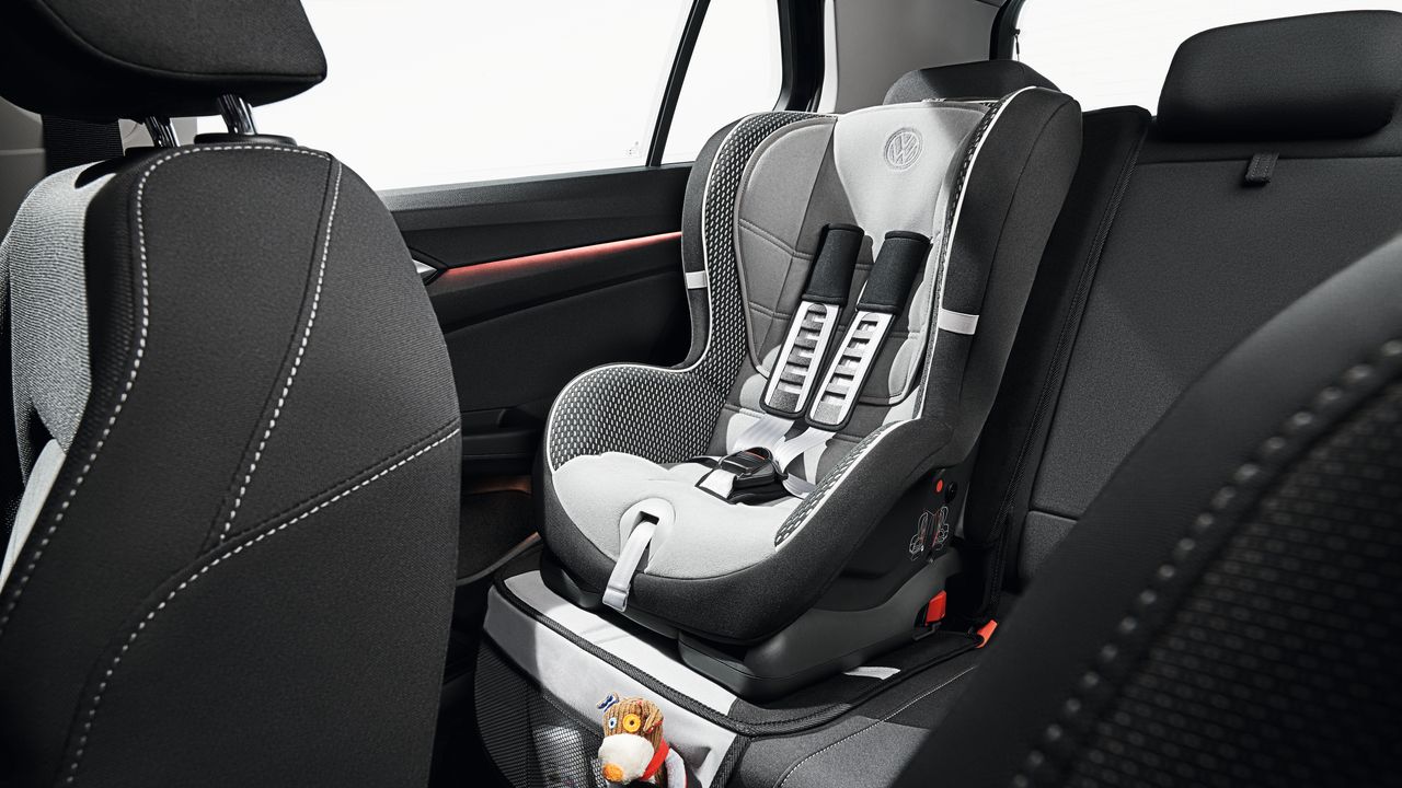 Why do we use Isofix? A vacant baby car seat being mounted on the right side of the backseat of a Volkswagen vehicle.
