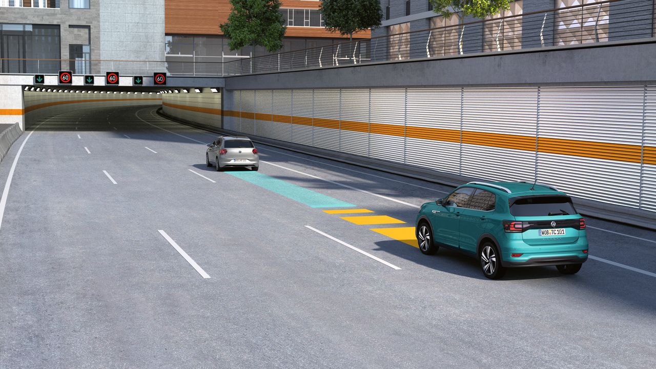 Driver Assistance | Adaptive Cruise Control (ACC) An image depicting a bright green Volkswagen vehicle trailing behind another vehicle at a safe distance on a highway.