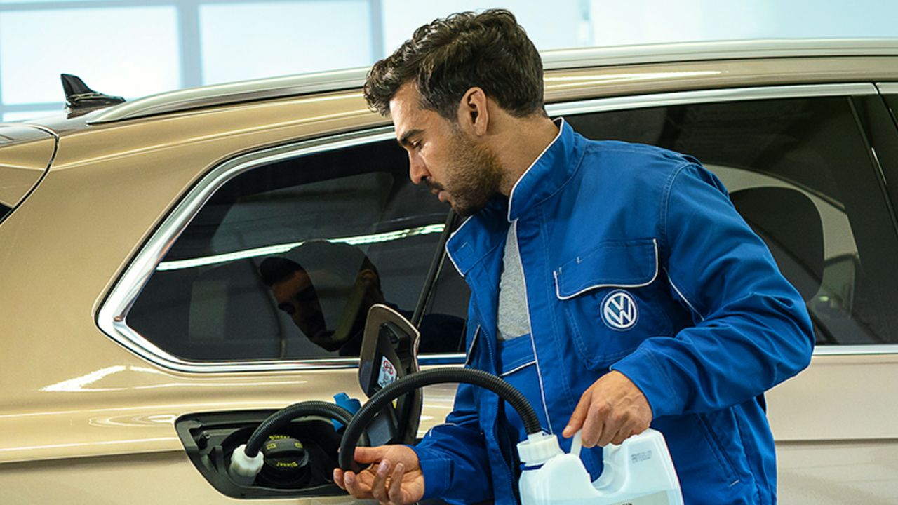 How does AdBlue system work? A Certified Volkswagen Technician filling AdBlue fluid into a Volkswagen vehicle.
