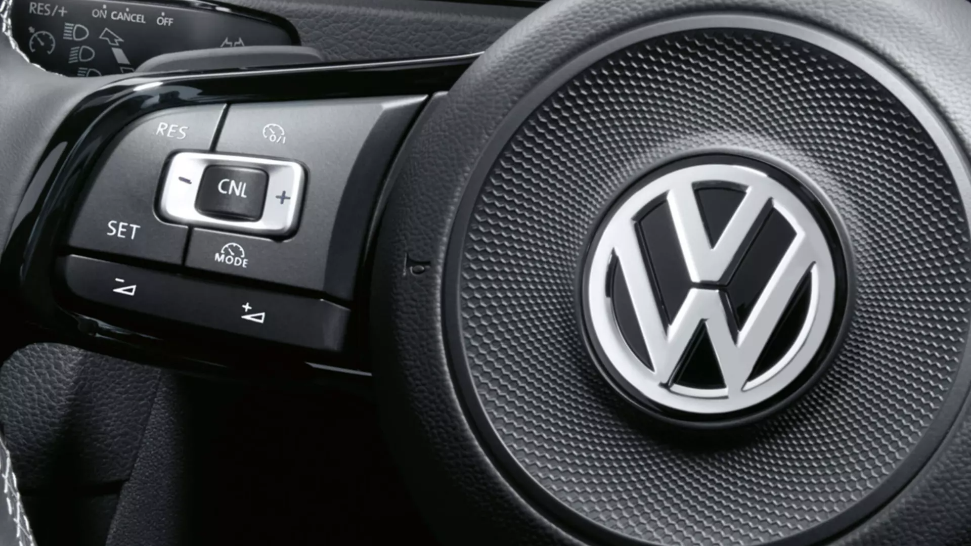 Driver Assistance | Cruise control A close-up look on a Volkswagen vehicle steering wheel with digital clusters.