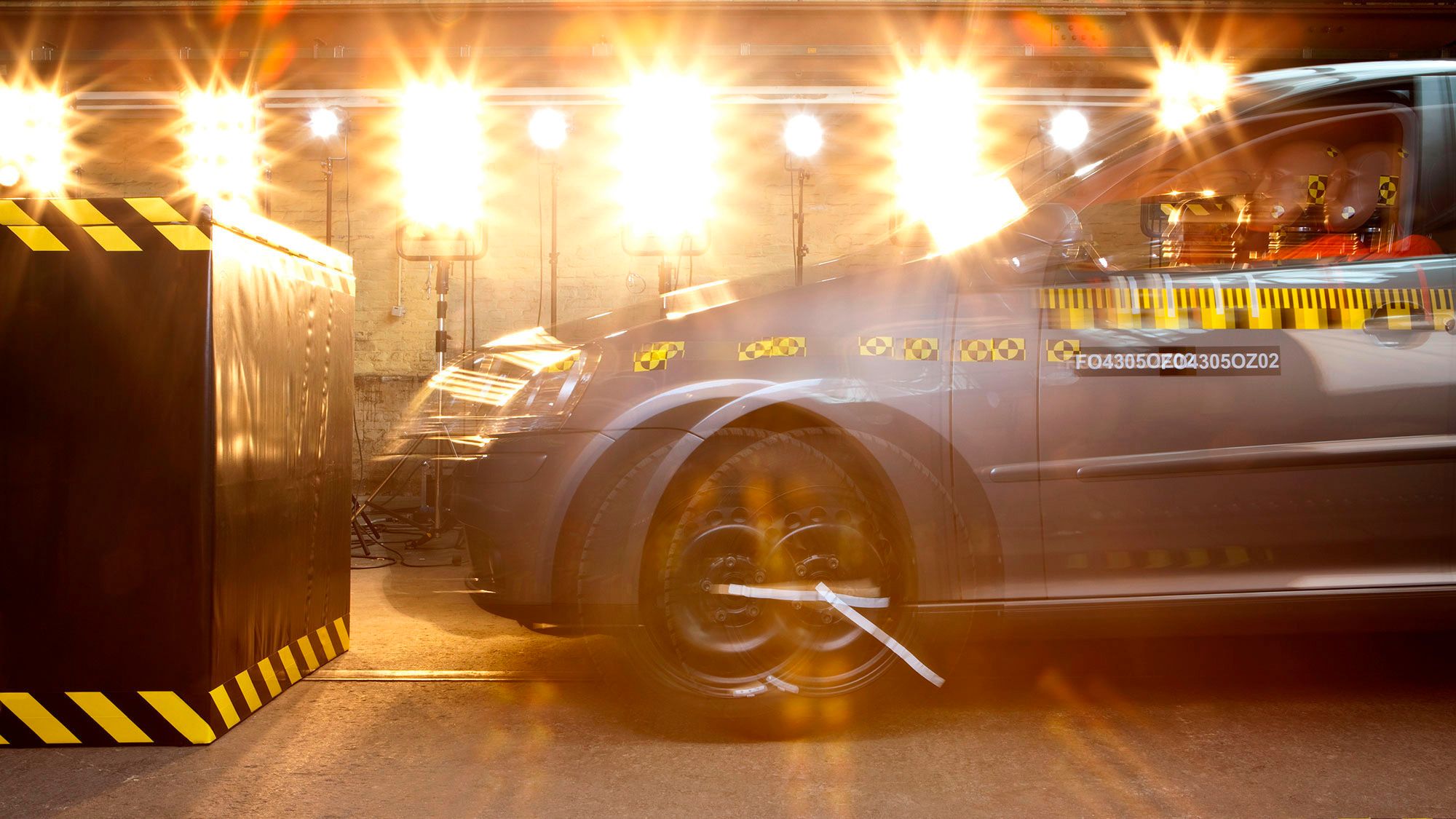 Euro NCAP | Safety testing A close up look of a vehicle going through a collision test in a secured and bright environment.