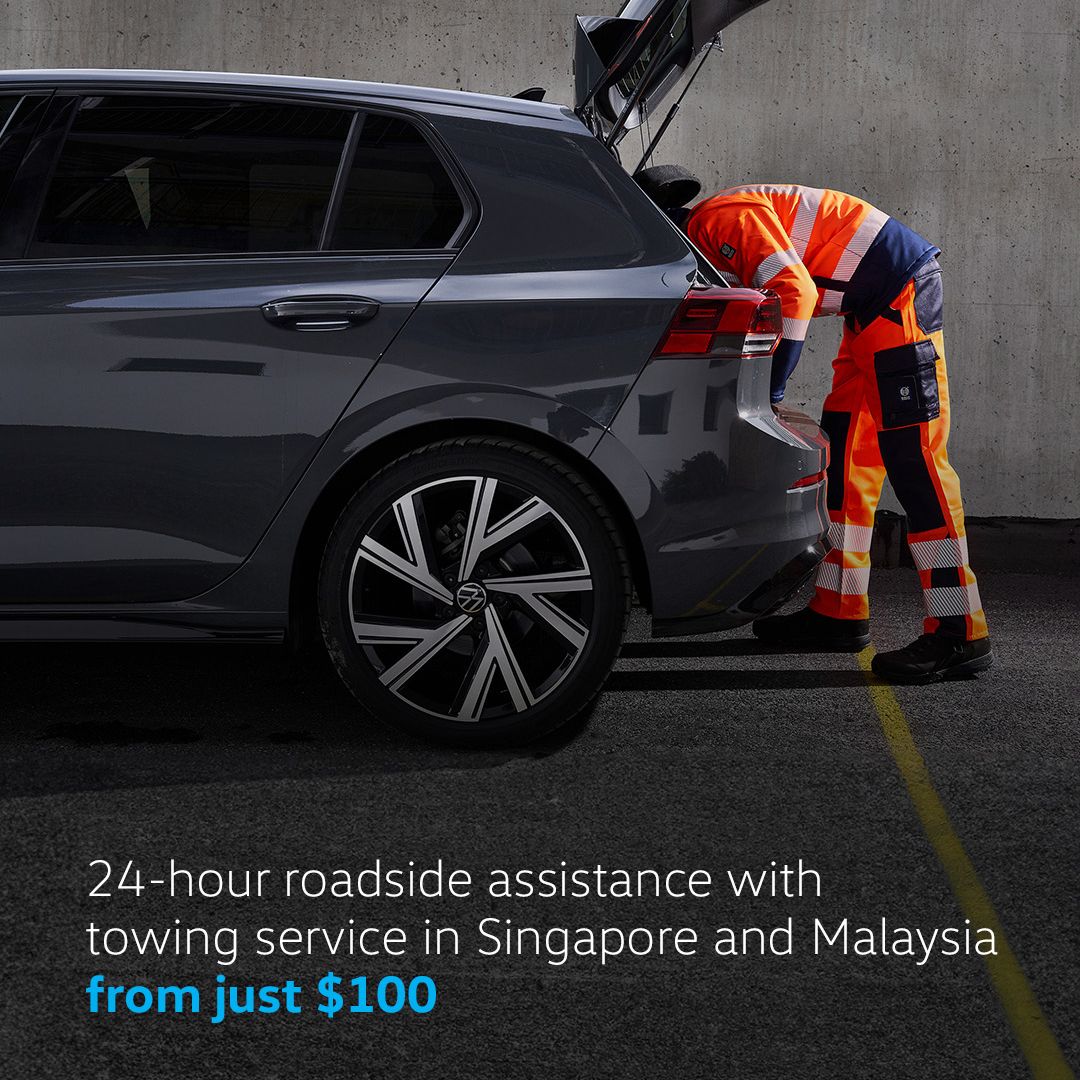 Roadside Assistance Services A trusted repairman providing Roadside Assistance to a parked Volkswagen.