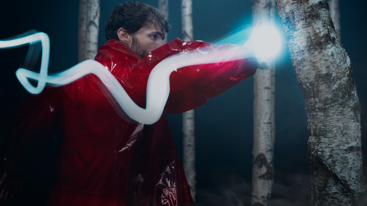 Moon power | EV Charging solution An individual dressed in striking red outfit is seen punching a tree in a studio setting.