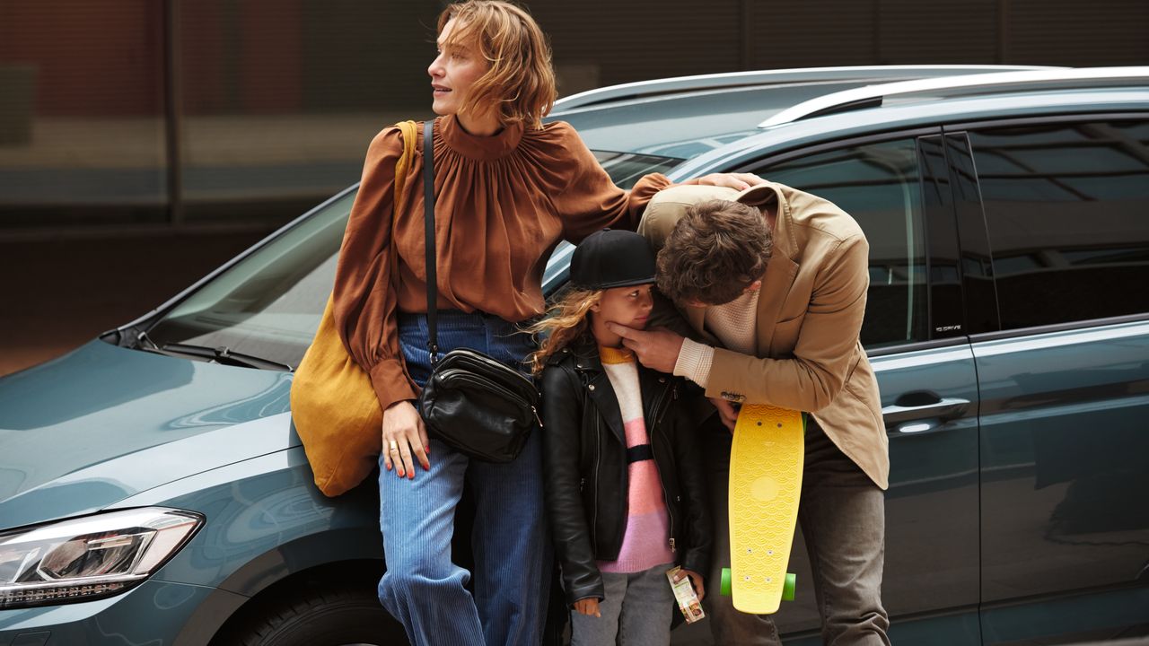 Electronic Engine Immobiliser A family standing beside of a parked Volkswagen vehicle while a parent is checking the condition of their child up-close at an outdoor urban area.