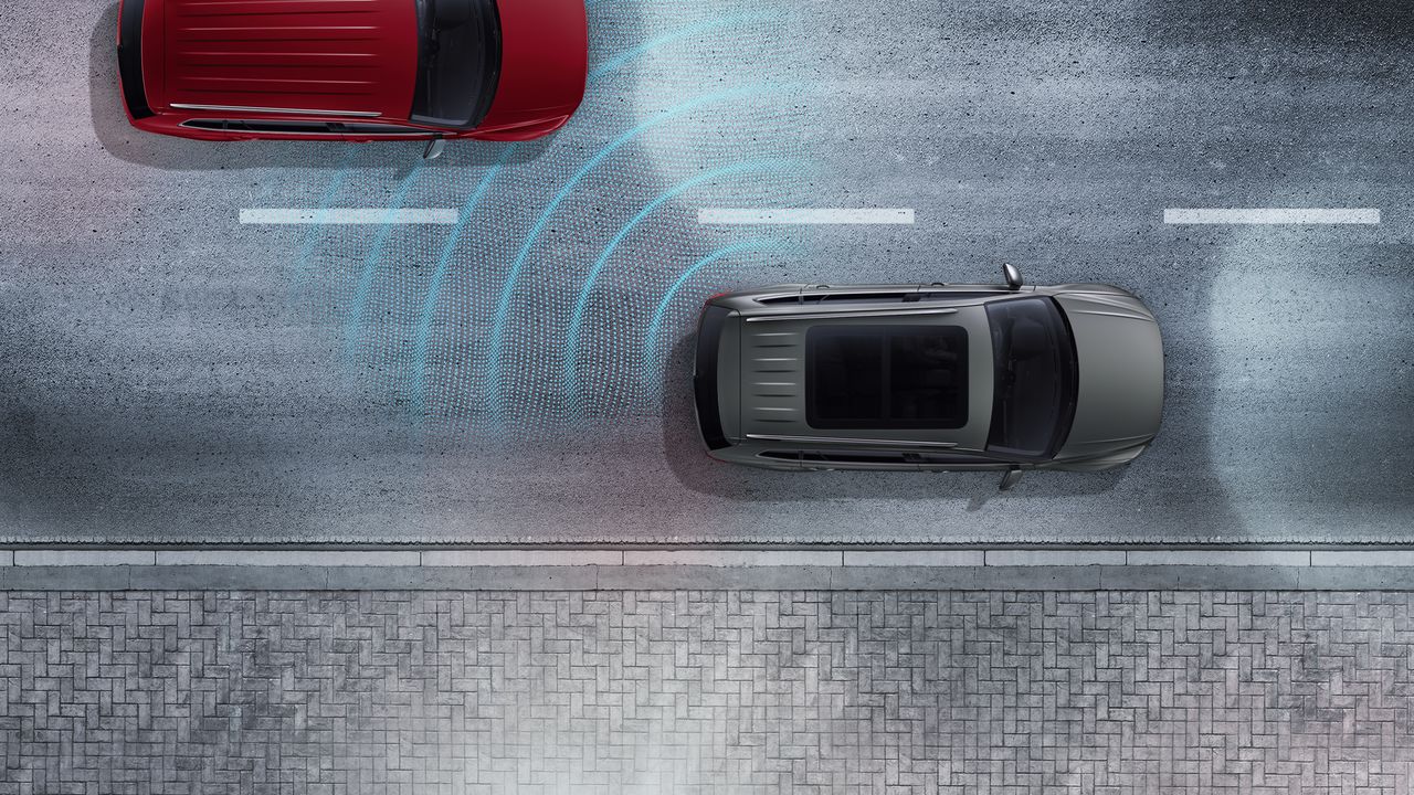 Driver Assistance | Side Assist An image depicting Side Assist signals being triggered to warn the driver of approaching traffic before changing lanes.